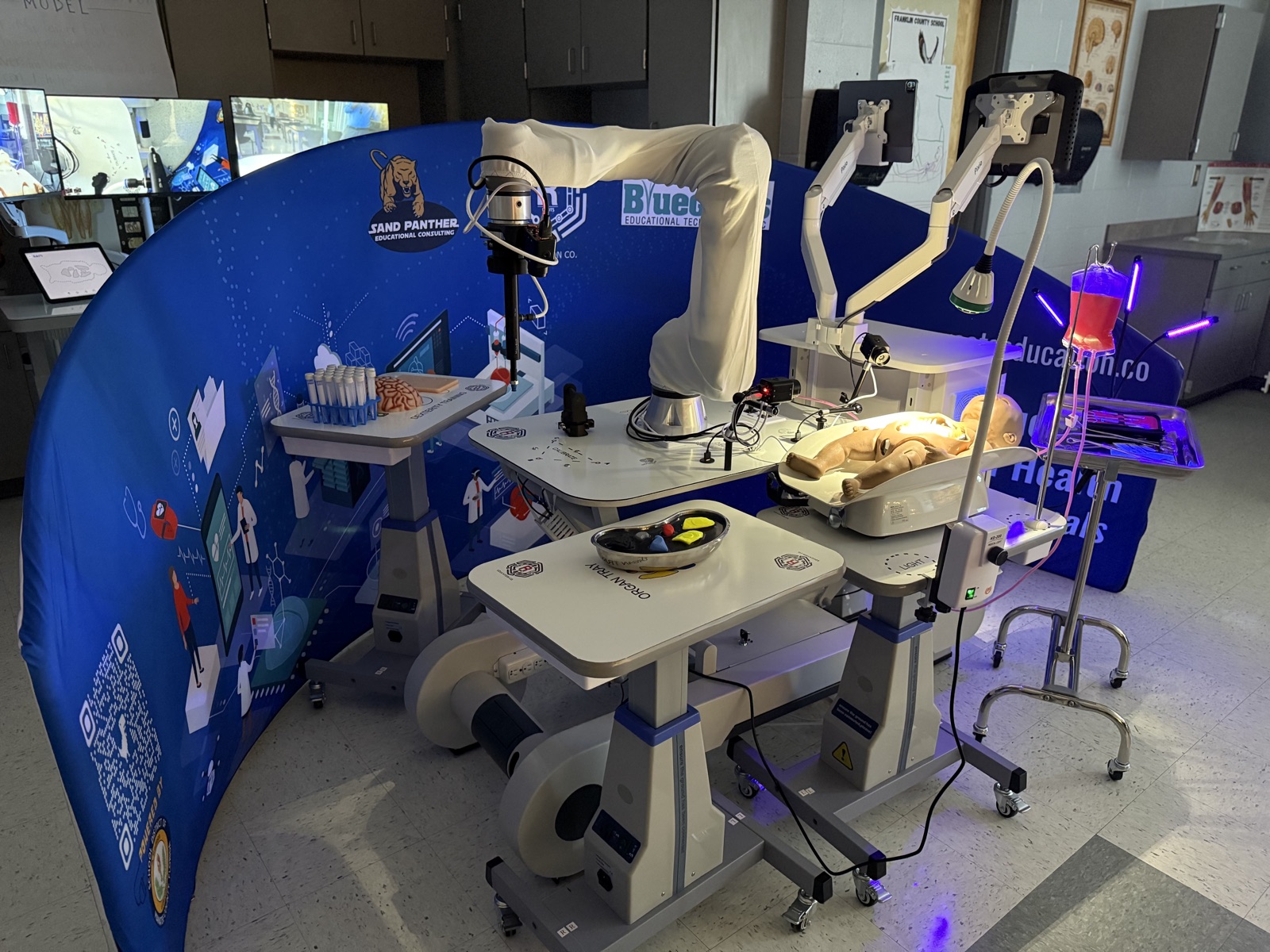 CARE healthcare robotics training lab with collaborative robot, simulation mannequin, cameras, and illuminated medical training equipment